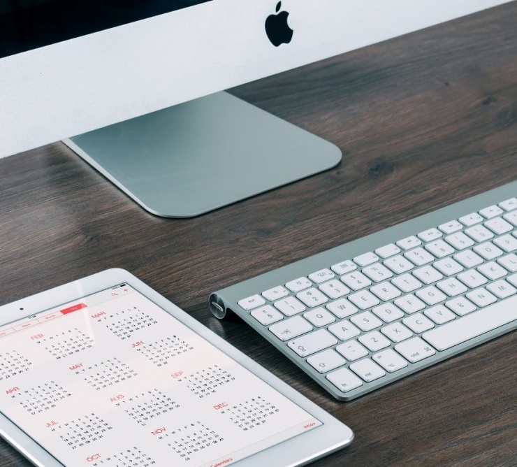 mac computer and tablet calendar on desk