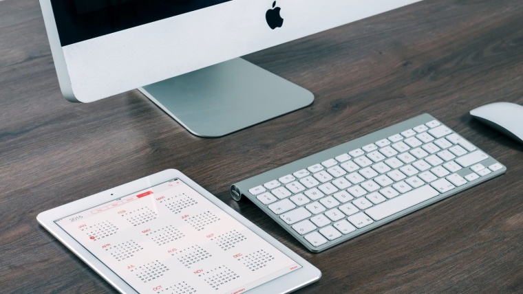 mac computer and tablet calendar on desk