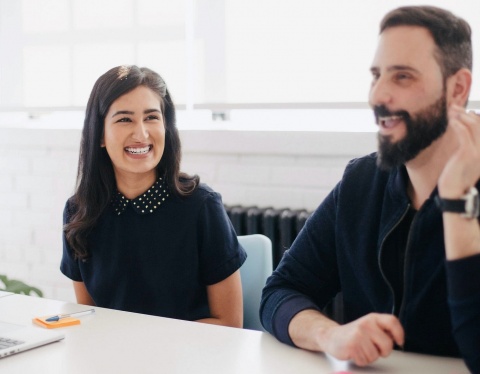 man and woman smiling in meeting discussion