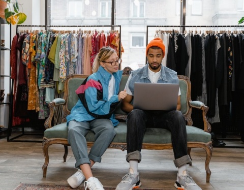 man and woman on laptop in shop looking at new products