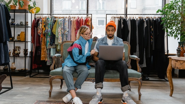 man and woman on laptop in shop looking at new products